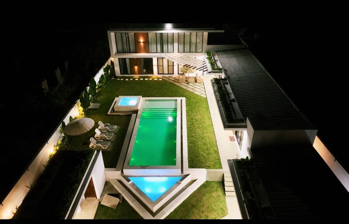 Aerial view of THE LOVLACE at night, the pool and villa lit from within