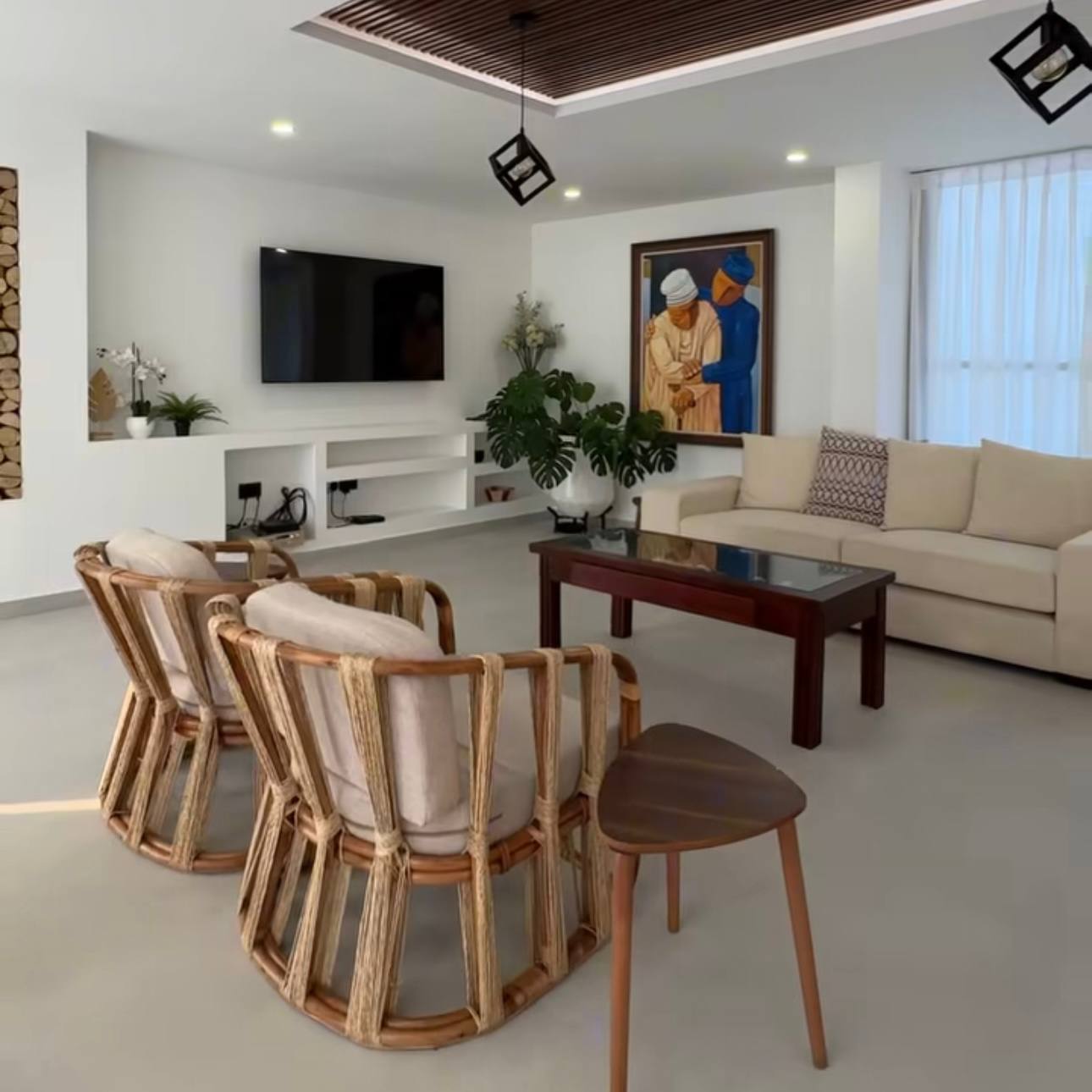 Living room with woven armchairs, neutral sofa and framed artwork